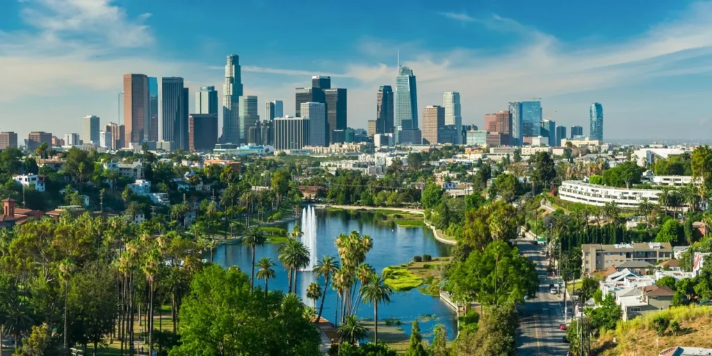 Cityscape with skyline buildings, lush trees, and a central lake fountain