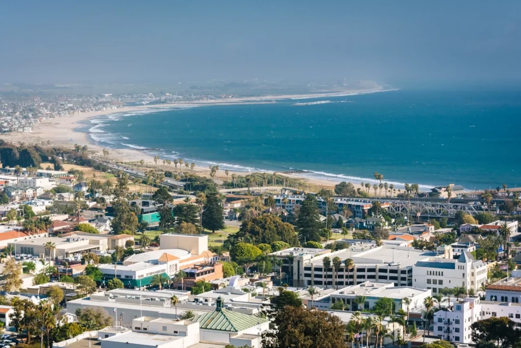 Aerial view of a coastal city with a beach, ocean, and buildings