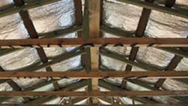 Wooden roof trusses with reflective insulation installed