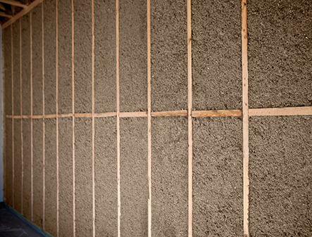 Natural insulation material filling wall studs in home construction