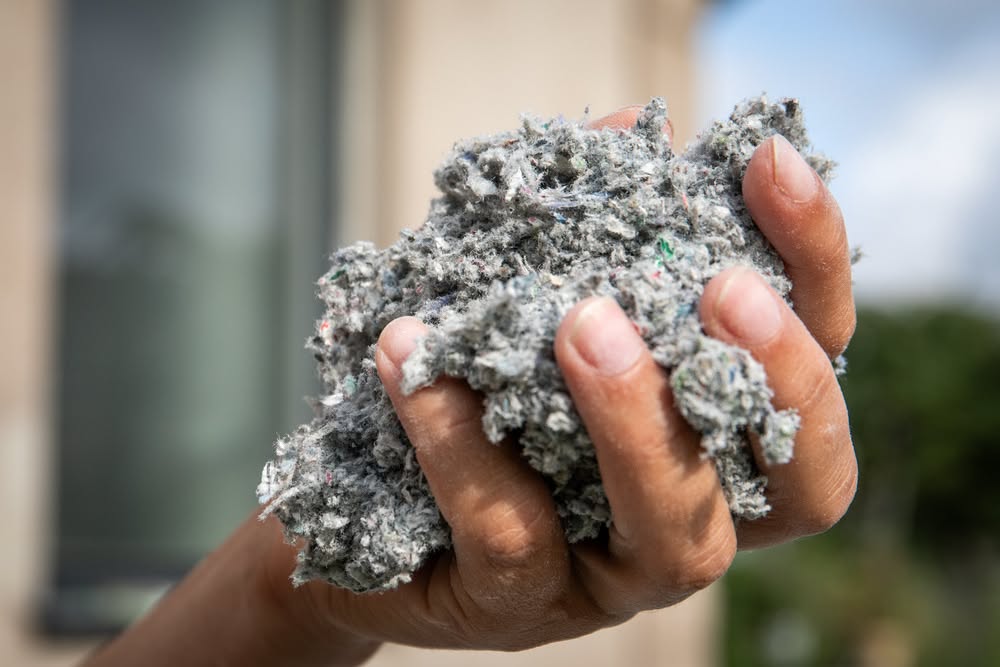 Hand holding attic insulation material for home improvement